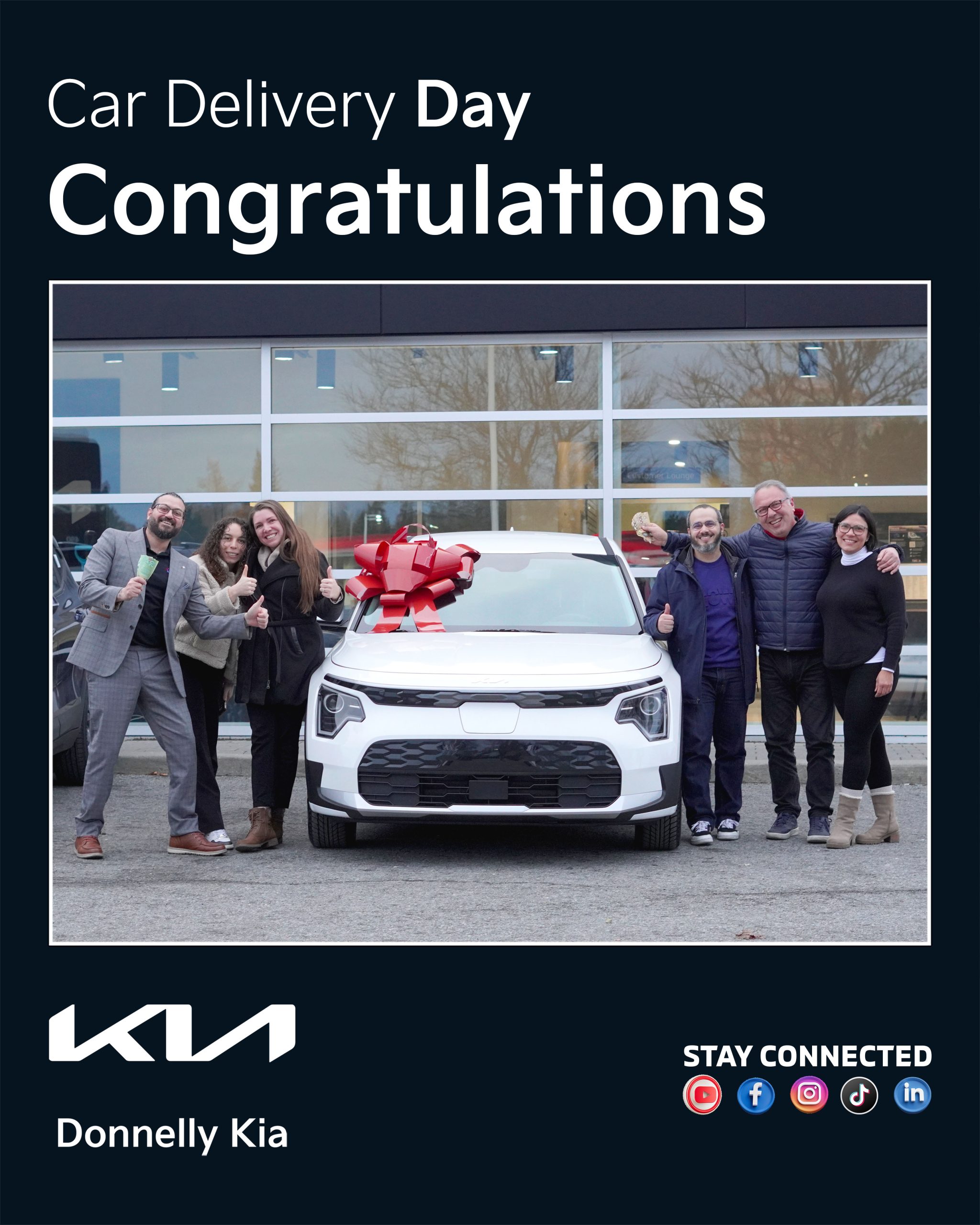 Happy family with their new Kia in front of Donnelly Kia